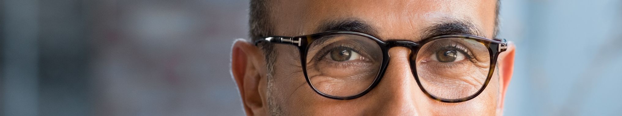 gentleman wearing round glasses looking towards the camera