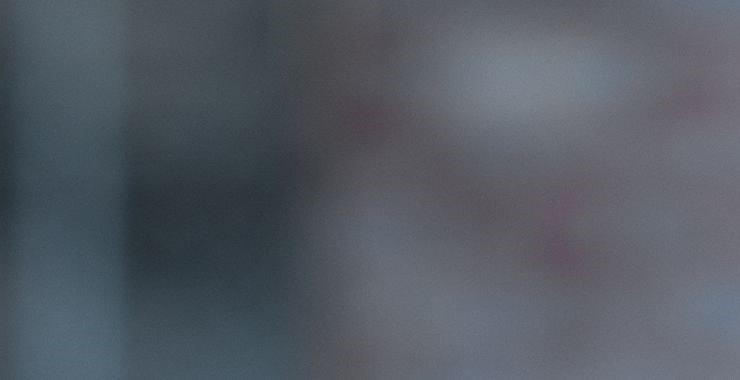 gentleman wearing round glasses looking towards the camera cropped
